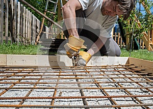 Low angle view of a man making a net of steel bar