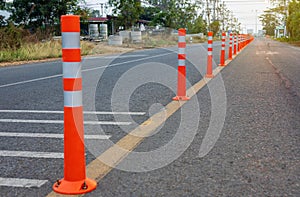 A low-angle view of many reflective orange plastic poles set up as a sign to prevent oncoming traffic