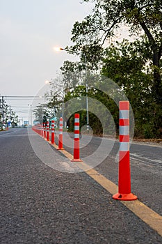 A low-angle view of many reflective orange plastic poles set up as a sign to prevent oncoming traffic