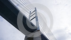 Low angle view of massive suspension bridge against the moody sky