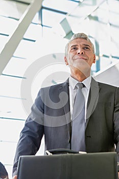 Low angle view of mature businessman queuing for check in at airport