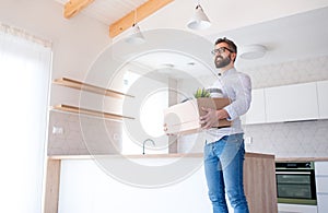 Low angle view of mature man with box moving in new unfurnished house.