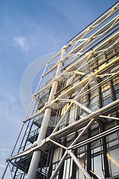 Low angle view of modern building construction under a blue sky and sunlight