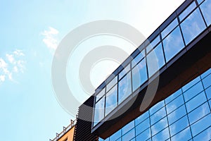 Low angle view of modern building with tinted windows against blue sky