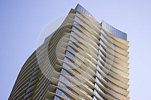 Low angle view of a modern corporate building with yellowish overhangs in each floor.