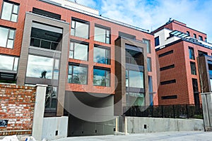 Low angle view on modern residential brick apartment building exterior with large windows. Modern Apartment Complex Under