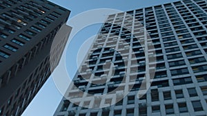 Low angle view of a multi storey building on blue sky background. Media. Newly built residential houses.