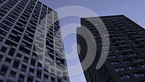 Low angle view of a multi storey building on blue sky background. Media. Newly built residential houses.