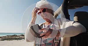 Low angle view old woman with car at the beach