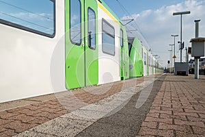 Low angle view at platform train station and Green and white regional train in DÃ¼sseldorf, Germany.