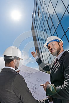 Low angle view of professional architects in hardhats working