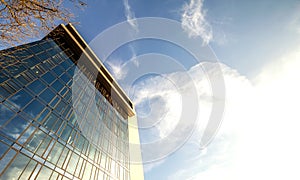 Low angle view of reflection of blue sky in glass wall of modern