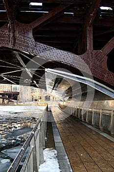 Low-angle view of a riverwalk alongside frozen Chicago River in January