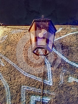 A lantern hanging on a wall, illuminated by soft light