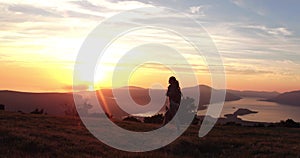 Low angle view of silhouette yong walking woman. Sporty woman walking at the mountains at the sunset. Fantastic view.