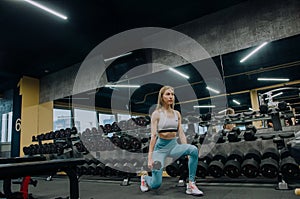 Low angle view of sporty young couple training with dumbbells in gym photo