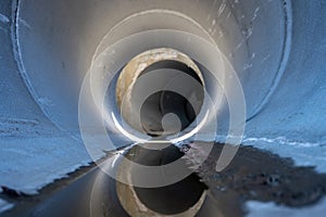 Low angle view of stormwater trickling through a large concrete culvert