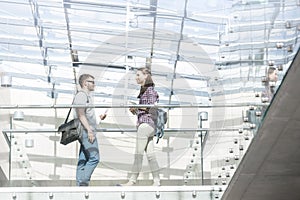 Low angle view of students walking on corridor at college