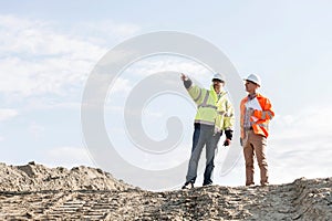 Low angle view of supervisor showing something to colleague at construction site