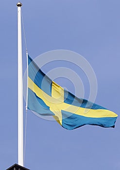 Low angle view of of a Swedish flag on half mast