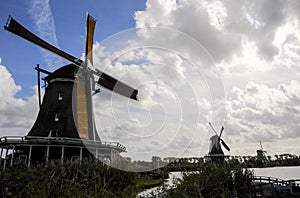 Low angle view of three Dutch Windmills with a dramatic sky in the background.