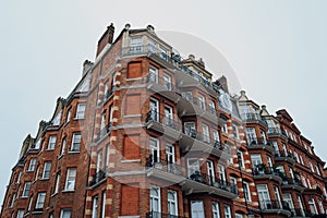 Low angle view of a traditional red brick apartment block in Kensington and Chelsea, London, UK