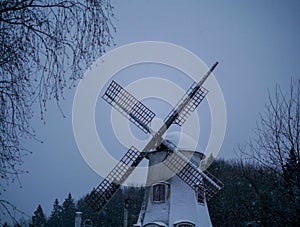 Low angle view of traditional windmill against sky during snowfall