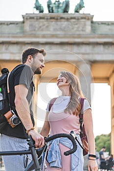 low angle view of travelers with backpacks and bicycle in front of Brandenburg Gate Berlin