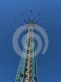 Low angle view of turning drop tower in famous amusement park Wurstelprater in Vienna, capital of Austria.