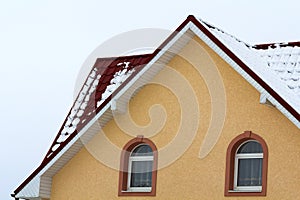 Low angle view of the upper floors of a new large house. Window and roof detail of residential home building. Real estate property