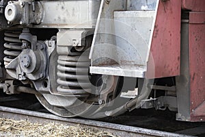 Low angle view of wheel mechanism of modern train locomotive on tracks. Steampunk, techno, power concept