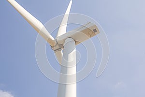 Low angle view of wind turbine against partly cloudy blue sky