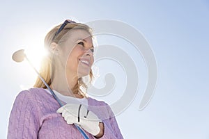 Low Angle View Of Woman Holding Golf Club Against Sky