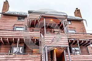 Low angle view of a wooden apartment building with two chimneys on the side