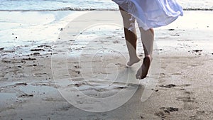Low angle view of young woman running towards the sea ocean with happy mood