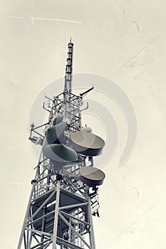 Low-angle vintage shot transmitters and aerials on telecommunication tower