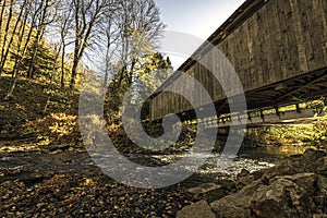 Low angle of wooden covered bridge in autumn