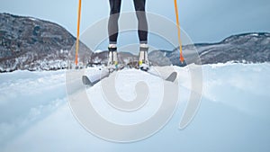 LOW ANGLE: Young woman nordic skiing in Slovenia pushes herself along the tracks