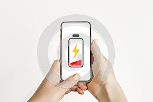 Low battery charge on your mobile phone. Female hand holding a low-charging smartphone isolated on white background