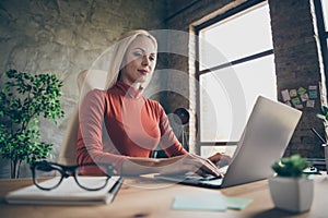 Low below angle view photo of qualified business lady working on her project by using laptop sitting at desktop