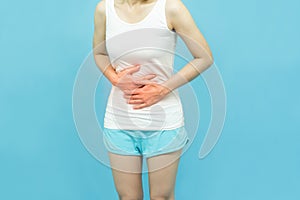 Low body of a woman in white tank top put her hands on the Stomach area mark red at spot of ache, abdominal pain, Health-care