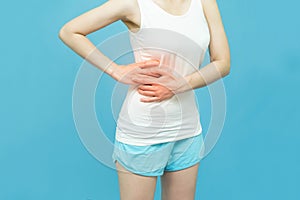 Low body of a woman in white tank top put her hands on the Stomach area mark red at spot of ache, abdominal pain, Health-care