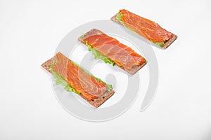Low caloric open sandwich with red fish. Isolated on white background
