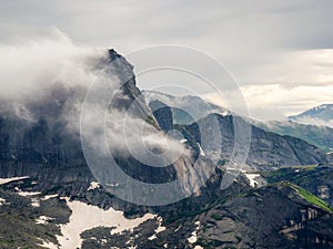 Low clouds and beautiful rockies. Dramatic fog among giant rocky