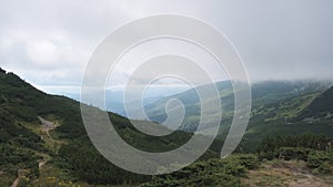 Low Clouds and Fog Slide Down the Mountain Slope in Strong Winds. Carpathians