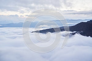 Low clouds, view of winter forest and mountains from observation deck, horizontal picture of amazing natural phenomenon. Beautiful