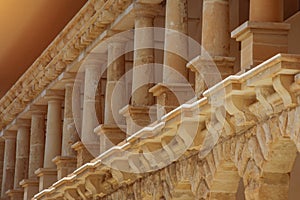 Low columns of orange limestone stone, elements of external architecture