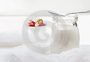 low-fat homemade yogurt with fresh strawberries on a light wooden background