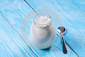 Low-fat yogurt in a glass jar with a spoon.