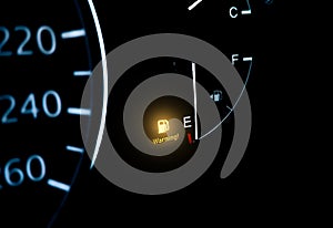 Low fuel indicator light on car dashboard